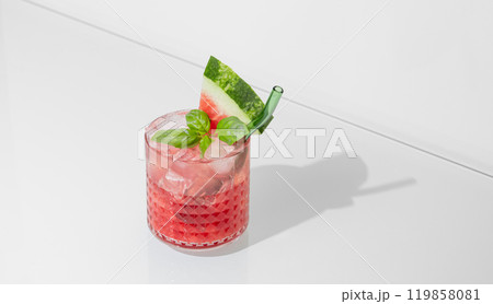 Glass of refreshing watermelon smoothie with basil, ice on white isolated background with shadow. 119858081