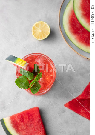 Flat lay of mojito cocktail with watermelon, lime, ice and mint in a  glass on a light background 119858105