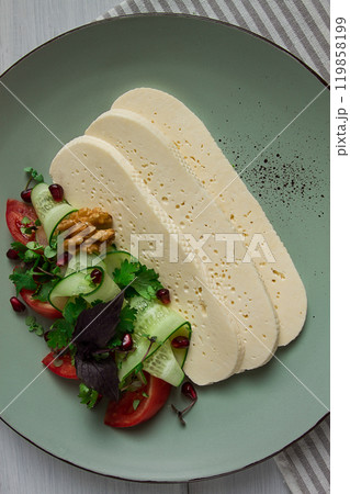 Sliced Imeruli cheese, Georgian cheese, with vegetables, top view, no people, Sliced Imeruli cheese, Georgian cheese, with vegetables, top view, no people, 119858199