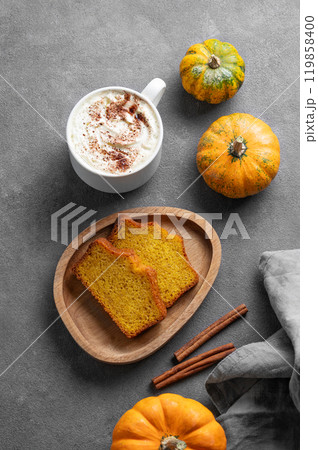 Slices of pumpkin sweet bread with cinnamon on a wooden board on a dark background  119858400