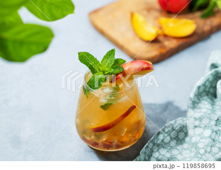 Refreshing peach cocktail, lemonade or iced tea on a light background with shadow. Refreshing peach cocktail, lemonade or iced tea on a light background with shadow. 119858695