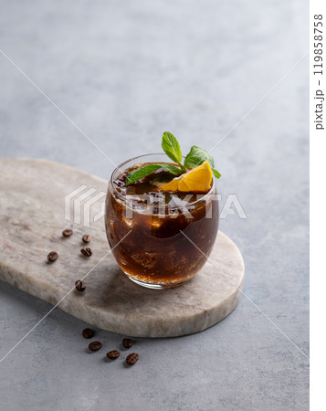 Coffee espresso with tonic in a glass with mint, ice and lemon on a marble board  119858758