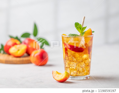 Refreshing peach iced mint tea. The concept of a healthy homemade cold summer drink in a tall glass Refreshing peach iced mint tea. The concept of a healthy homemade cold summer drink in a tall glass 119859197