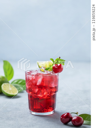 Cherry-lime mojito cocktail with mint, lime and ice on a blue background with fresh berries. Cherry-lime mojito cocktail with mint, lime and ice on a blue background with fresh berries. 119859224