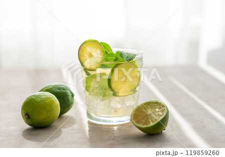Citrus lemonade in a glass with mint and ice. Refreshing mojito cocktail with lime  119859260