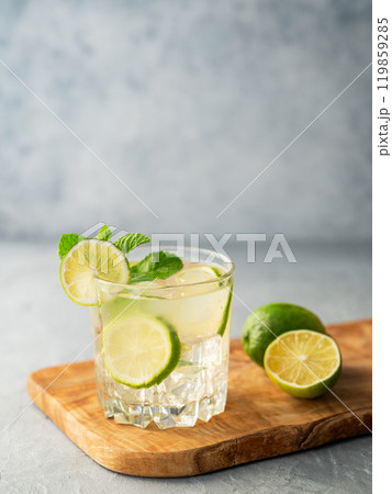 Mojito drink with fresh lime on a wooden board on a texture blue background. 119859285