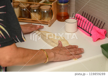 Woman folding dough to make buns Woman folding dough to make buns 119859289