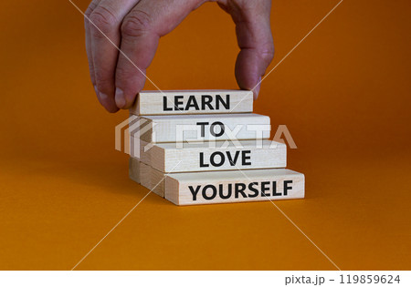 Learn to love yourself symbol. Concept words 'Learn to love yourself ' on wooden blocks on a beautiful orange background. Businessman hand. Business, psychological and learn to love yourself concept. 119859624