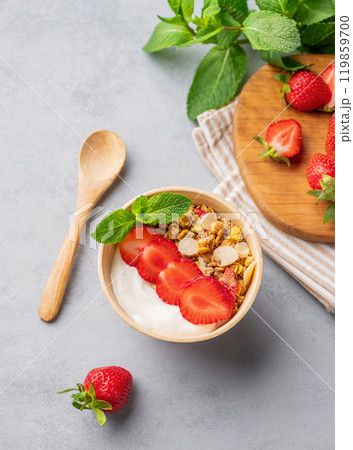 Natural yogurt with muesli and strawberries in a bowl on a blue background 119859700