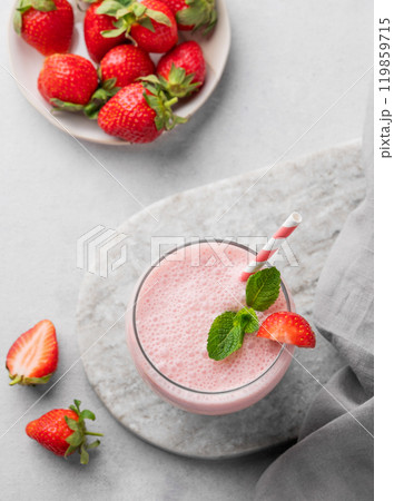A glass of fresh strawberry smoothie with mint on a marble board on a light background  119859715