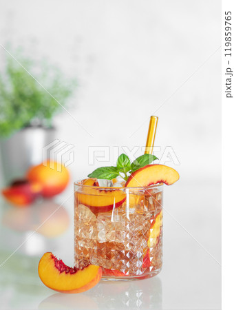 Peach refreshing drink with ice and mint on a white background. Fresh homemade lemonade in a glass Peach refreshing drink with ice and mint on a white background. Fresh homemade lemonade in a glass 119859765