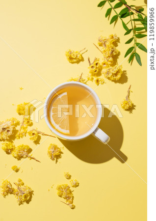 Herbal tea with immortelle and lemon in a white cup on a yellow background. Herbal tea with immortelle and lemon in a white cup on a yellow background. 119859966