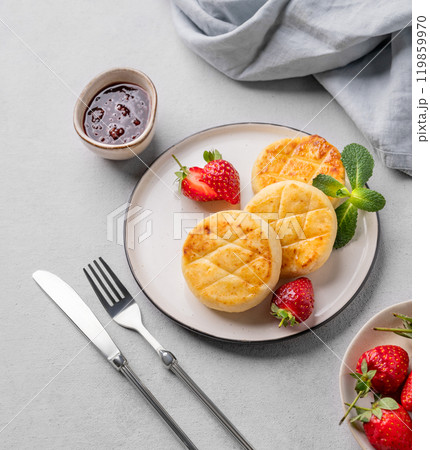 Cottage cheese, cheesecakes or syrniki with strawberries, berry jam and mint leaves  119859970