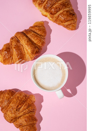 Flat lay of coffee cup and fresh croissants on pink  background with shadow. 119859995