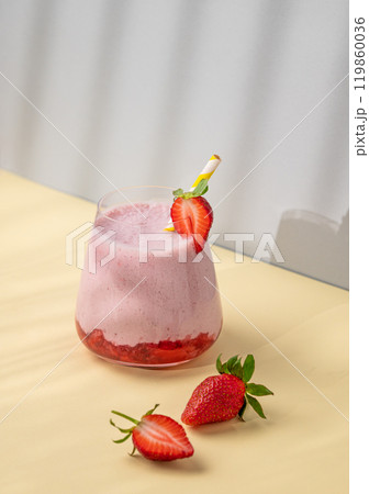 A strawberry milkshake or smoothie in glass with strawberries on a yellow background A strawberry milkshake or smoothie in glass with strawberries on a yellow background 119860036
