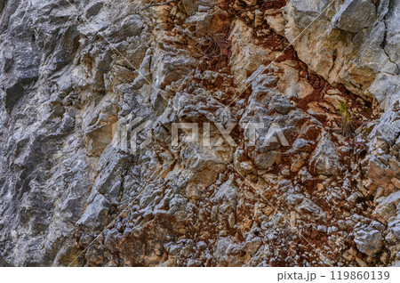 Detailed texture of a rocky cliffside showcasing natural patterns and colors in a remote outdoor location during daylight Detailed texture of a rocky cliffside showcasing natural patterns and colors in a remote outdoor location during daylight 119860139