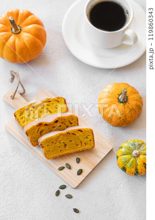 Pumpkin sweet bread or cake with icing on a wooden board on a light background Pumpkin sweet bread or cake with icing on a wooden board on a light background 119860343