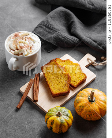 Slices of pumpkin sweet bread with cinnamon on a wooden board on a dark background  119860361
