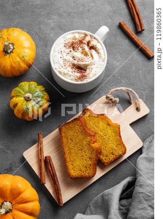Slices of pumpkin sweet bread with cinnamon on a wooden board on a dark background  119860365