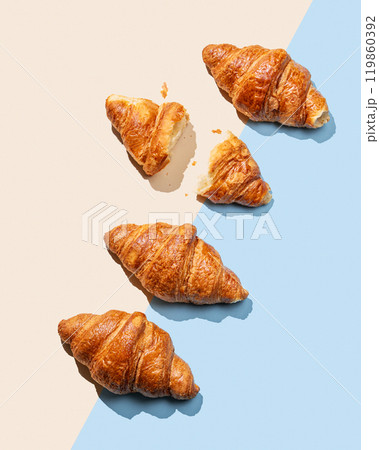Flat lay of fresh croissants on yellow and blue background with shadow. Flat lay of fresh croissants on yellow and blue background with shadow. 119860392