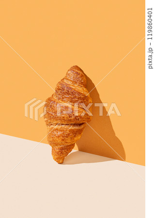 Fresh croissant on yellow background with hard shadow. Fresh croissant on yellow background with hard shadow. 119860401