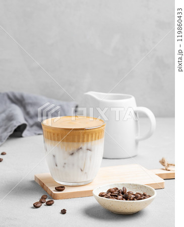Iced dalgona coffee. Whipped instant coffee in a glass with ice on a wooden board 119860433