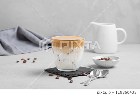 Dalgona coffee. Whipped instant coffee in a glass with ice on a slate board on a gray background Dalgona coffee. Whipped instant coffee in a glass with ice on a slate board on a gray background 119860435