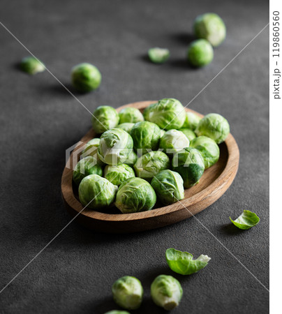 Fresh raw brussels sprouts in a wooden plate on a dark background close up. 119860560