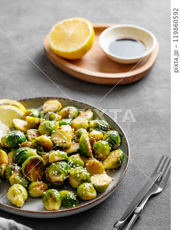 Crispy brussels sprouts in a plate with soy or balsamic sauce and sesame on a dark  background  119860592