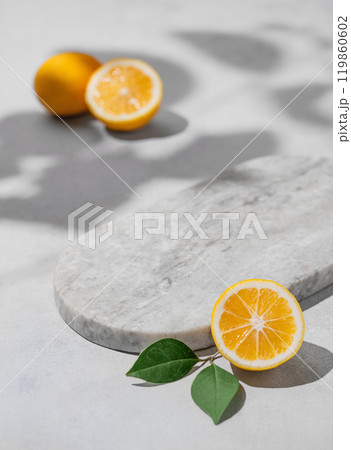 Lemon slices and leaves, marble empty board on gray background with shadow. 119860602