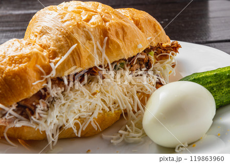 Croissant sandwich with tuna on a white plate on a dark table close up side view Croissant sandwich with tuna on a white plate on a dark table close up side view 119863960