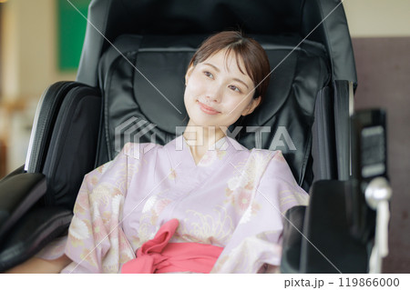 マッサージ機でリラックスする若い女性 119866000