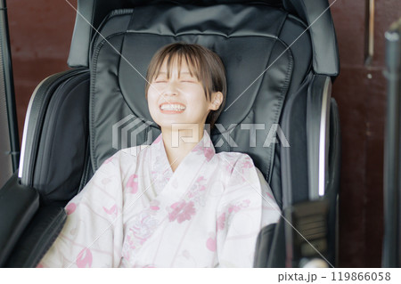 マッサージ機でリラックスする若い女性 マッサージ機でリラックスする若い女性 119866058