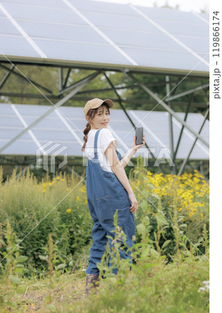 太陽光パネルの前に立つ女性 119866174