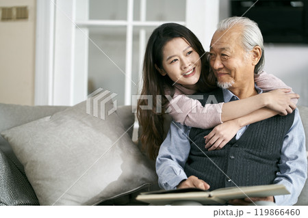 elderly asian father and adult daughter conversing at home 119866460
