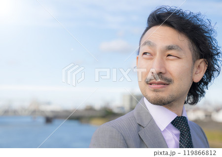 青空で振り返る見上げる中年男性ビジネスマンのクローズアップ　転職求人などのイメージに　背景に街並みや 119866812