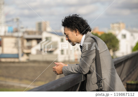 夕陽の中何もかもうまくいかず、落ち込む中年男性　氷河期世代や中年クライシス中年の危機などのイメージ 119867112