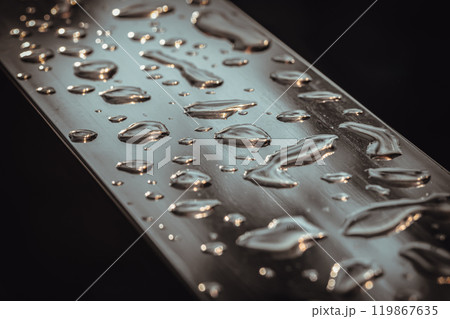 Detail of Water droplets caused by rain perched on the metallic surface. 119867635