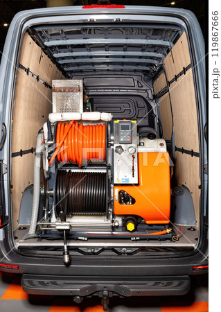 High-pressure cleaning equipment installed in van interior with hoses and cleaning tools organized for efficient work, industrial cleaning concept High-pressure cleaning equipment installed in van interior with hoses and cleaning tools organized for efficient work, industrial cleaning concept 119867666