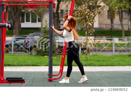 Woman walking near fitness equipment in park 119869052