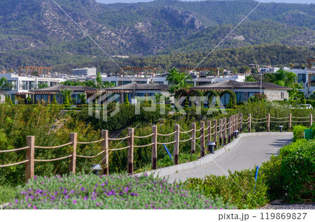 Picturesque landscape showcasing resort architecture nestled among lush greenery in a serene mountain backdrop on a sunny day 119869827