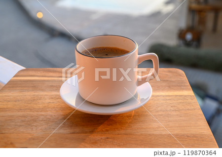 Black coffee in a mug on the background of the pool 119870364