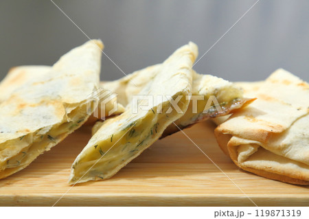 Lavash with baked cheese. Lavash with baked cheese on a wooden board. Lavash with cheese. 119871319