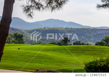 A serene afternoon view of rolling green hills and distant mountains at a peaceful golf course surrounded by nature 119871515