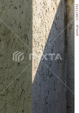 Sunlight casts a dramatic shadow on textured walls, highlighting the interplay of light and surface in a quiet corner Sunlight casts a dramatic shadow on textured walls, highlighting the interplay of light and surface in a quiet corner 119871542