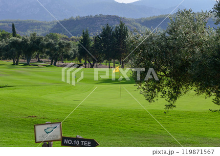 A tranquil afternoon on the lush golf course, featuring the tenth tee and a distant flag swaying gently in the breeze 119871567