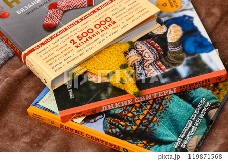 A Cozy Collection of Knitting Books Featuring Colorful Sweaters and Creative Patterns on a Warm Wooden Surface 119871568