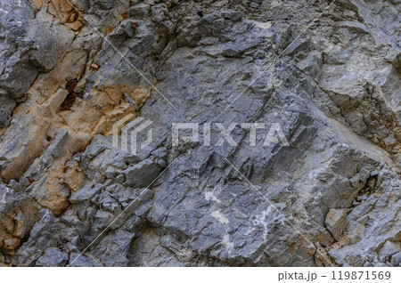 Rugged granite cliff face showcasing weathered textures and geological formations in a natural landscape under soft daylight 119871569
