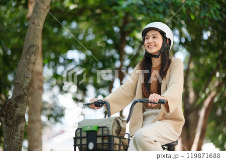 A woman is riding a bicycle with a basket on the front A woman is riding a bicycle with a basket on the front 119871688