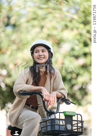 A woman is sitting on a bicycle with a basket on the front 119871756